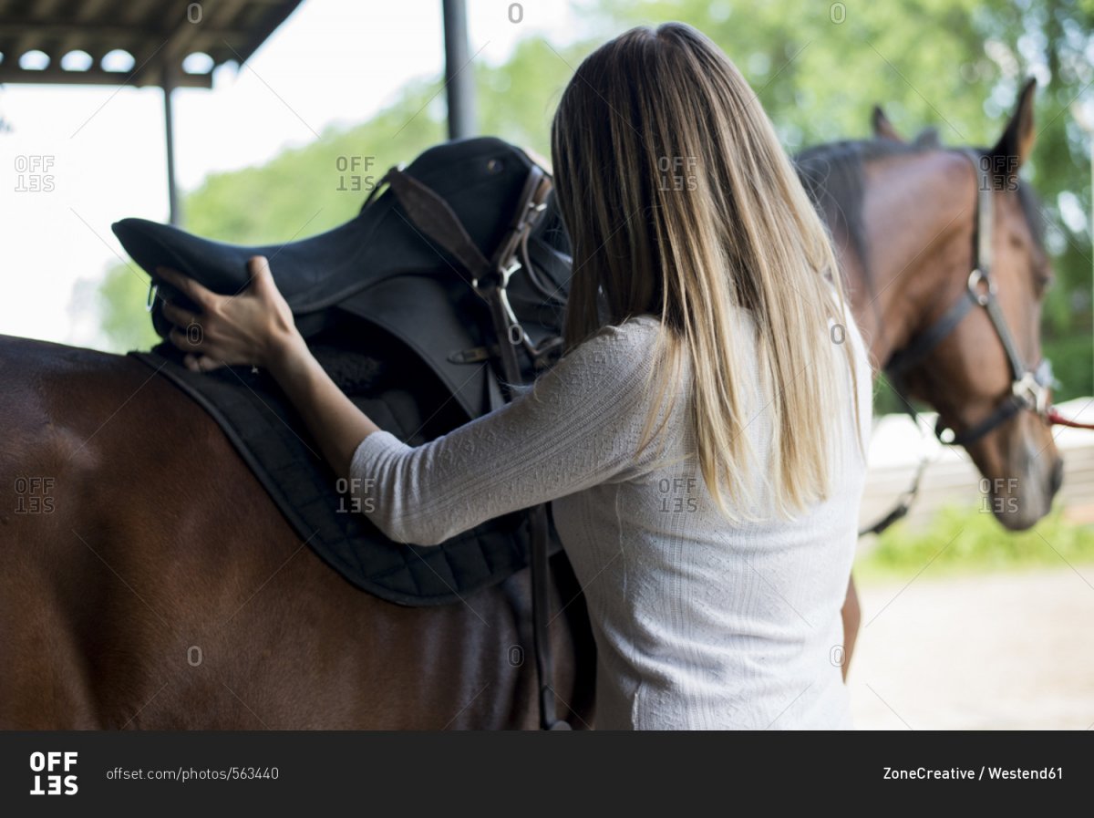 Блондинка на лошади со спины