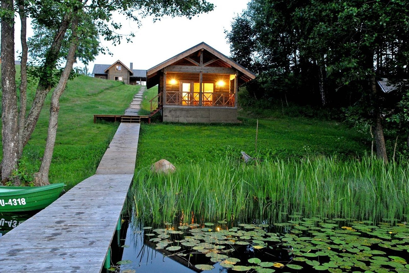 Дача рядом с водой. Тини Хаус на берегу озера. Уютный домик банька в деревне у реки. Домик у озера.