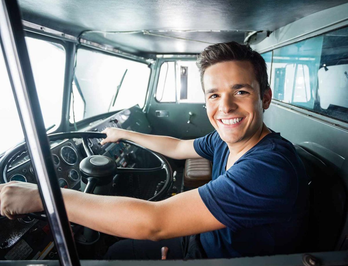 Водитель дальнобойщик улыбается