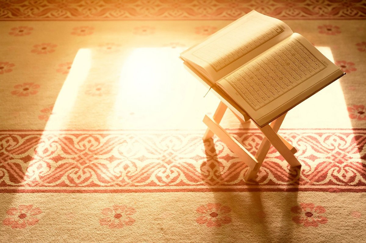 Коран на подставке на фоне