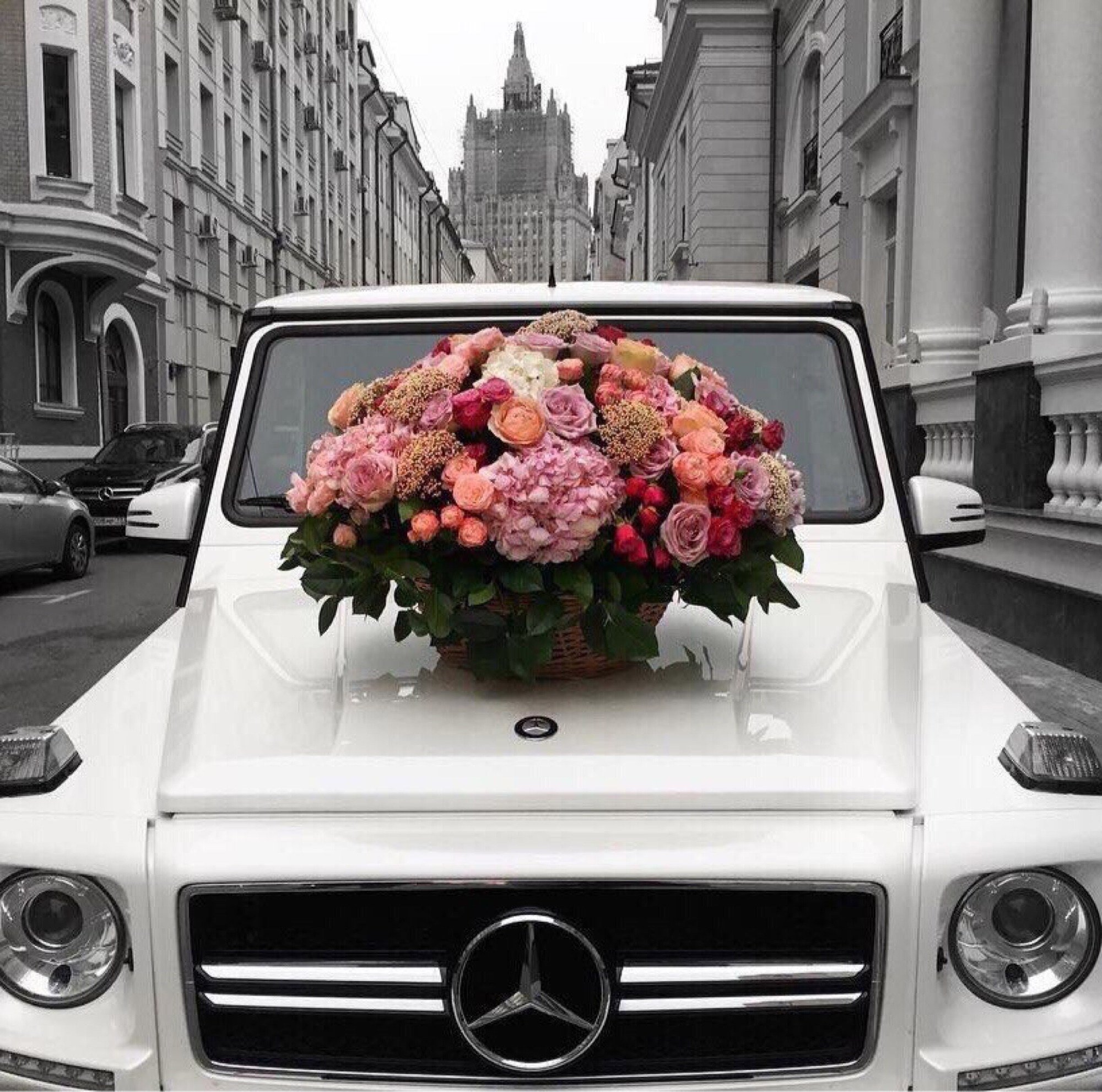 Грузовик с тюльпанами. Мерседес Гелендваген лимузин. Машина с цветами. Розы в машине. Букет на капоте машины.