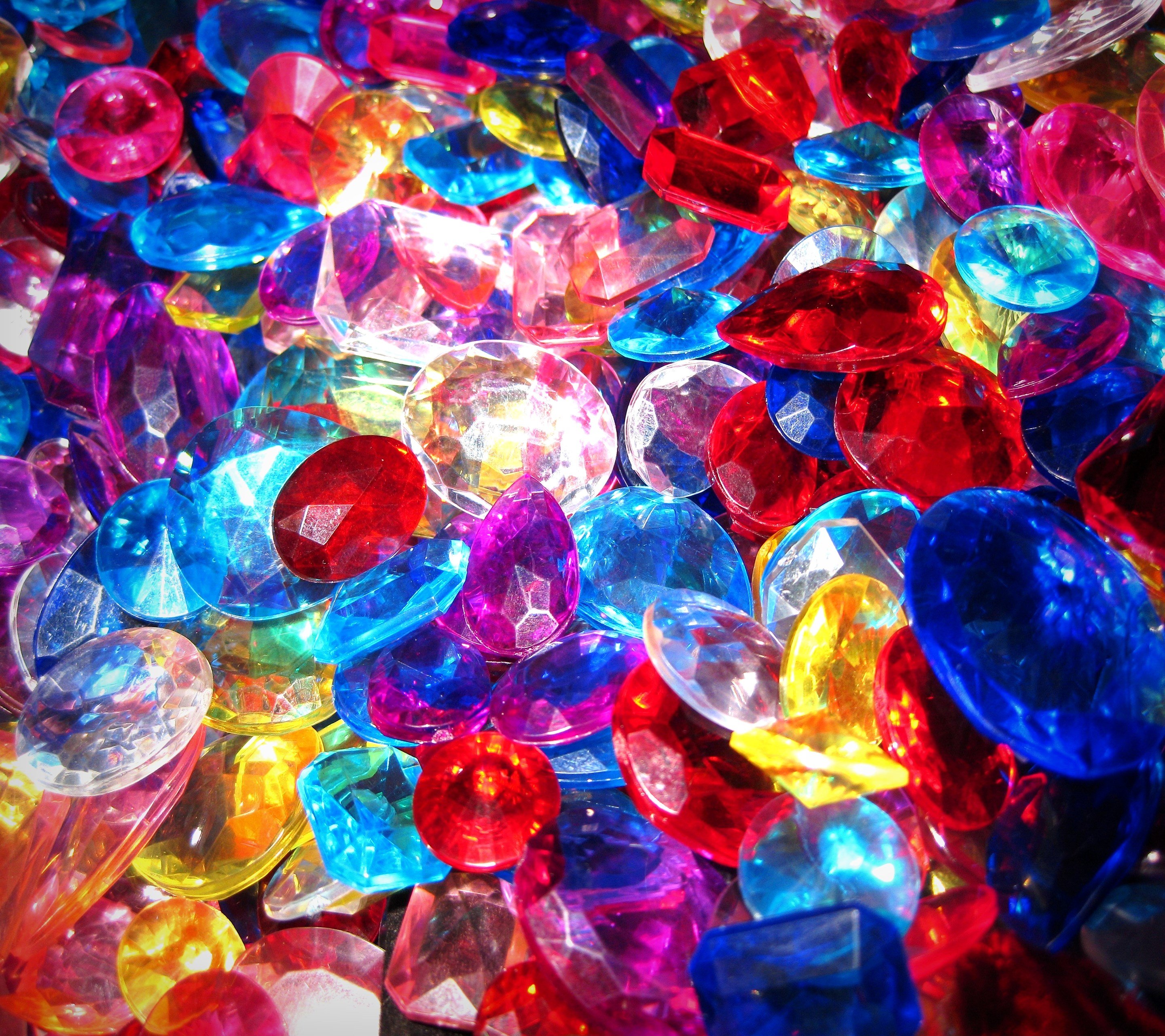 Самоцветы для детей. Разноцветные камешки. Разноцветные Кристаллы. Цветные драгоценные камни. Россыпь драгоценных камней.