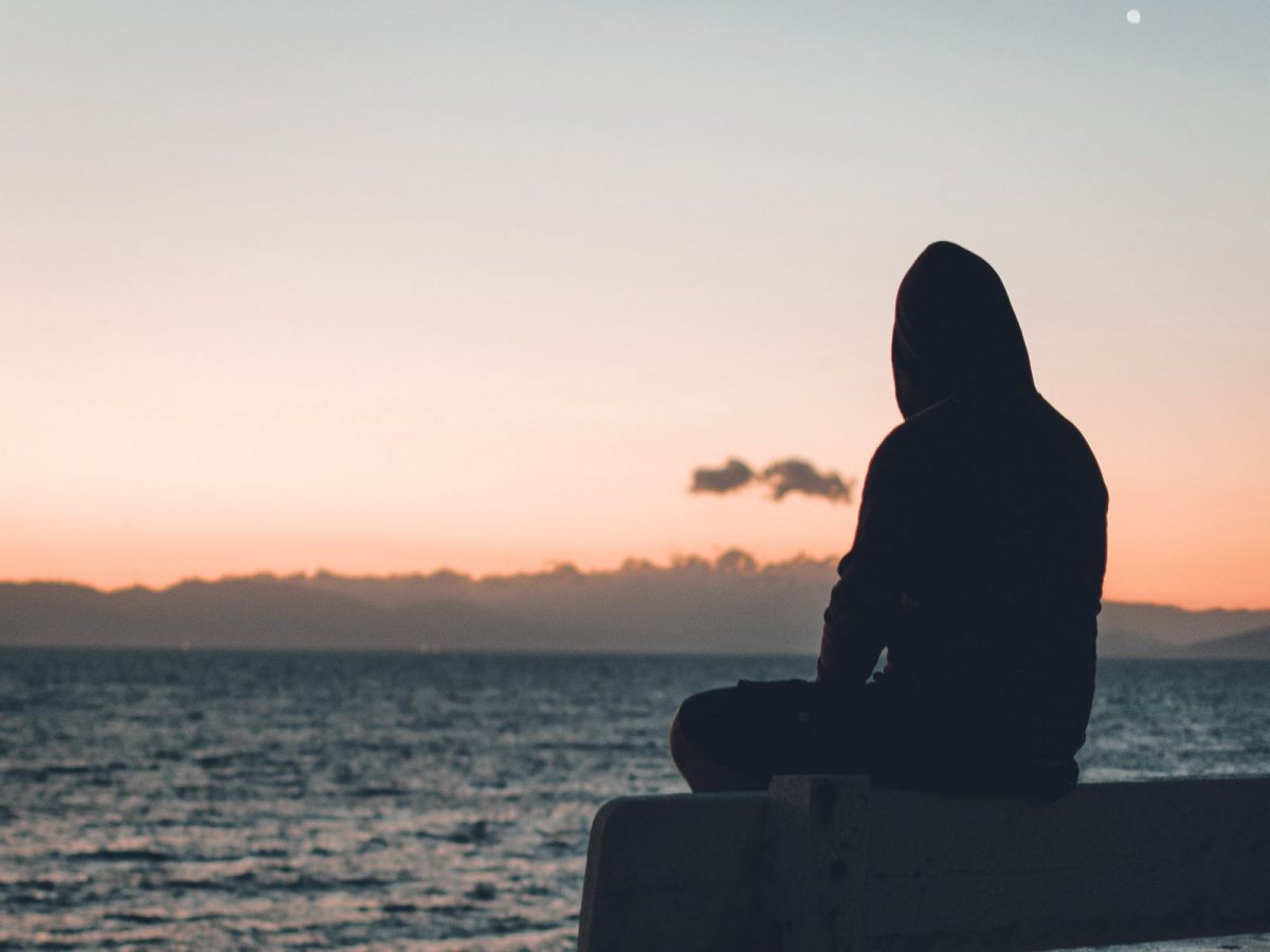 В капюшоне возле машины